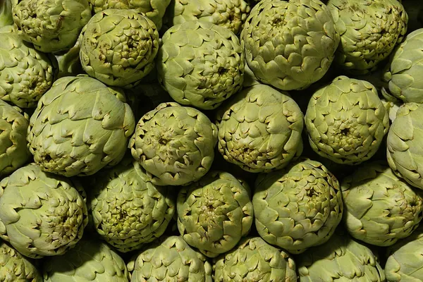 Whole globe artichokes at a market