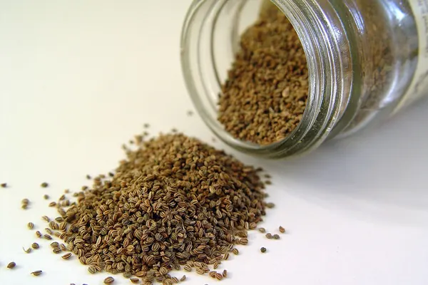 Celery seeds spilling from a glass jar