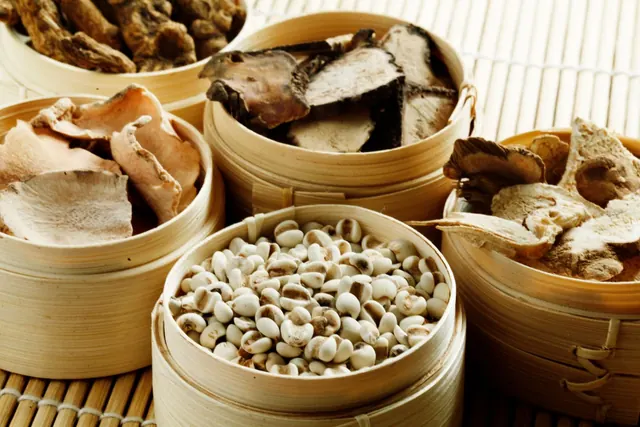 Assorted dried traditional Chinese herbs in bamboo baskets (illustrative photo)