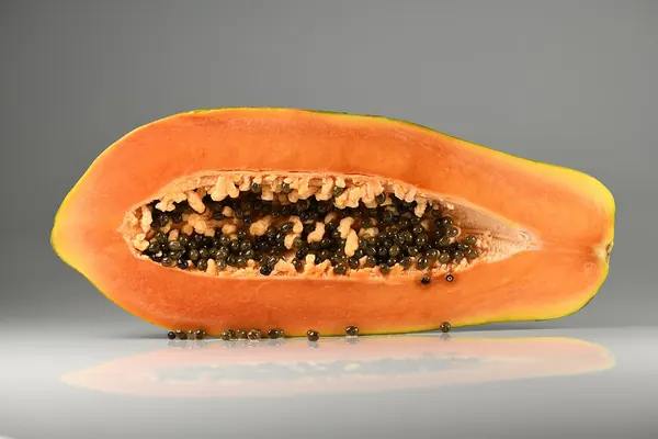 A papaya cut lengthwise showing its seeds