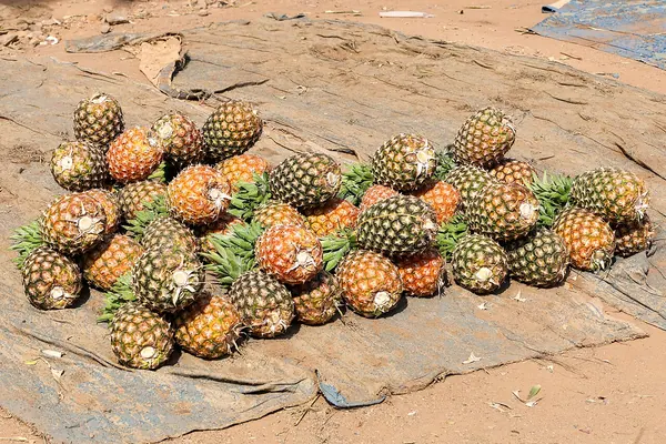 A pile of whole pineapples at a market